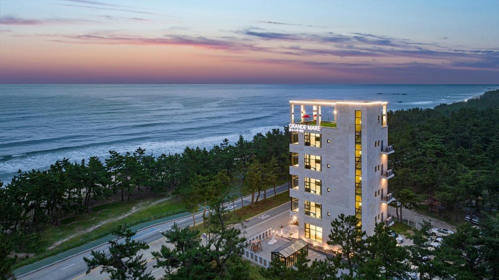 江陵市にあるGangneung Grande Mare Pool Villaの夕日の海辺の建物