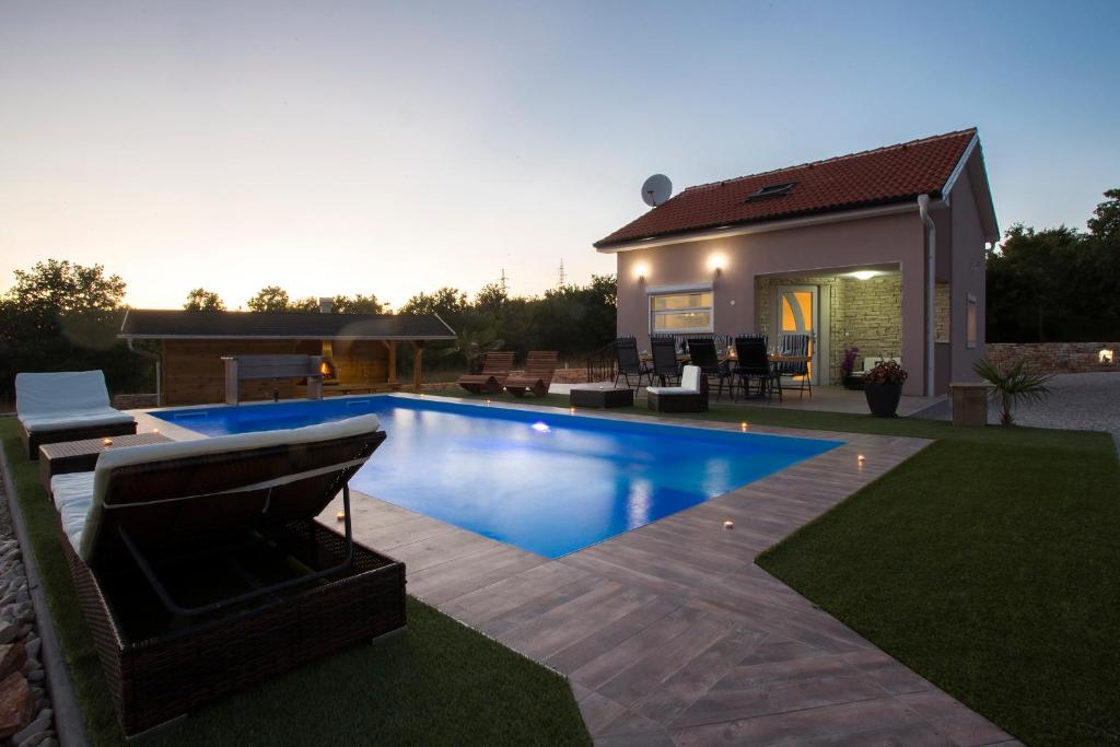 a swimming pool in front of a house at Galizana Peaceful Vacation home in Galižana