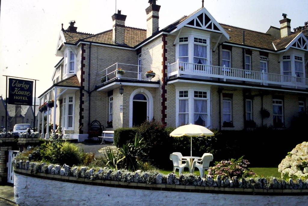 ein Haus mit einem Tisch und einem Sonnenschirm davor in der Unterkunft Varley House in Ilfracombe