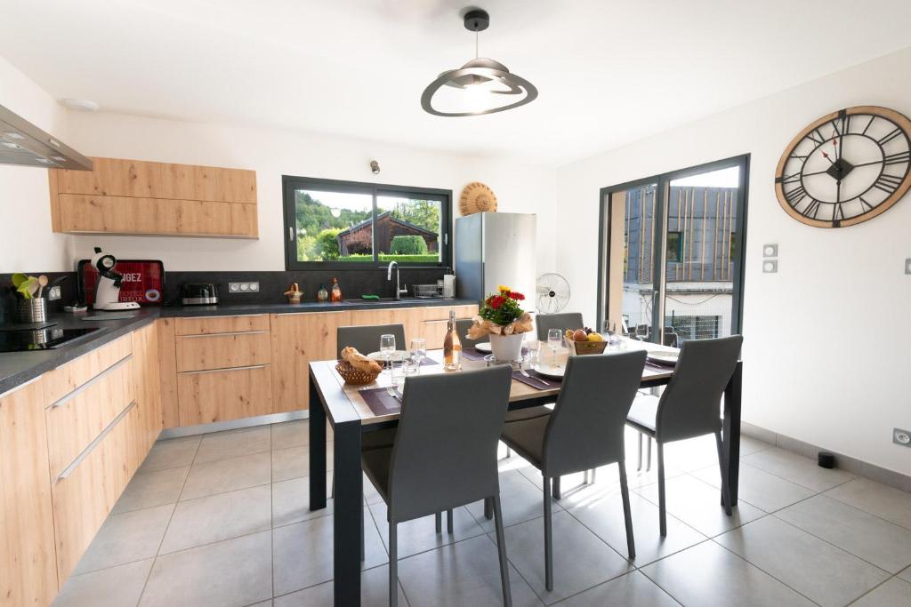 a kitchen and dining room with a table and chairs at Entre genêts et chardons in Banassac