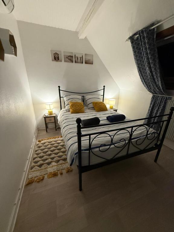 a bedroom with a black bed with yellow pillows at 3 pièces centre ville ville pittoresques parking gratuit à 5 minutes à pied in Obernai