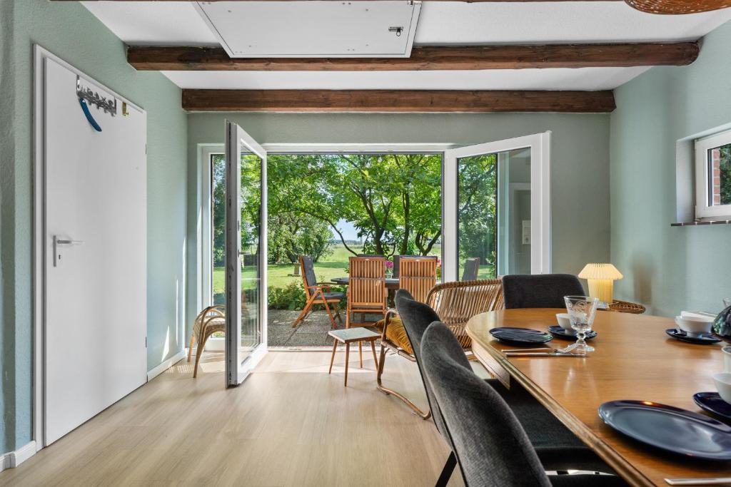 a dining room and living room with a table and chairs at Villa Wilma Hinte in Suurhusen
