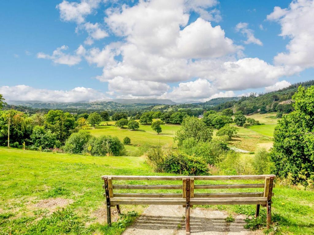 un banc en bois assis dans un champ herbeux dans l'établissement 1 bed property in Bala 89368, à Llandderfel