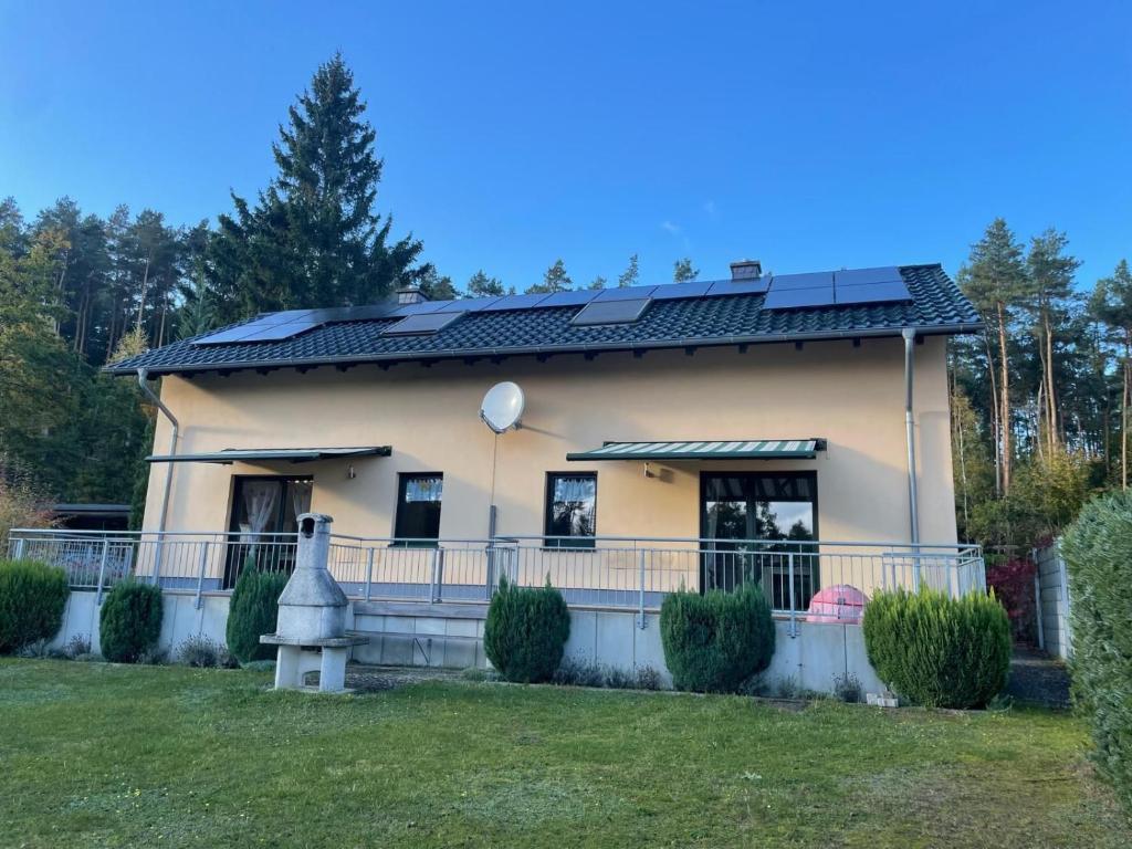滨湖克拉科Doppelferienhaus am See & Wald的屋顶装有太阳能电池板的房子
