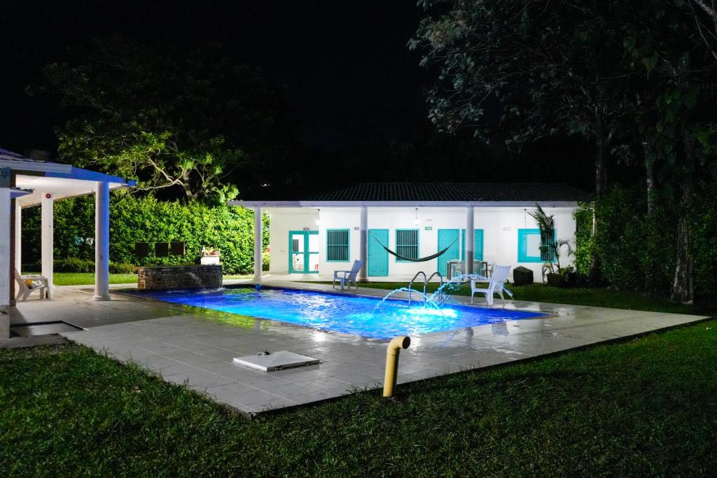 a swimming pool in a yard at night at Casa Hotel Villa Sabrosura in Mariquita