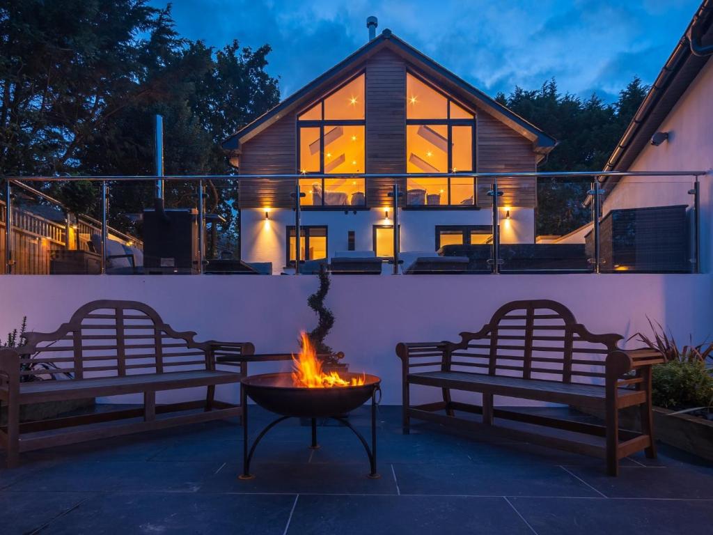 two benches and a fire pit in front of a house at 4 Bed in Westward Ho 86640 in Bideford
