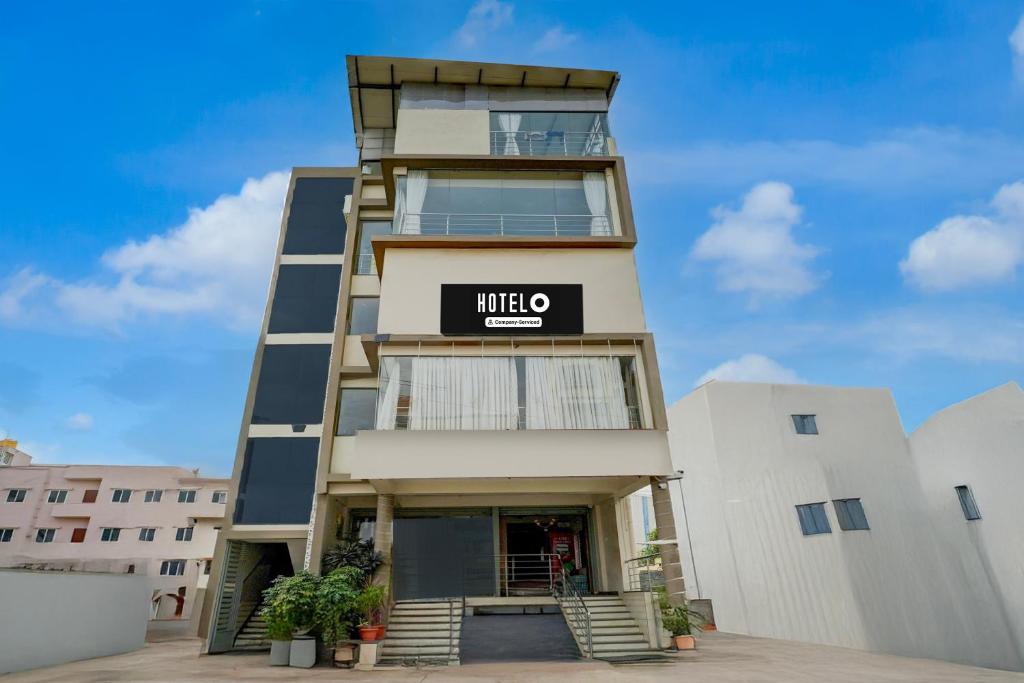 un edificio alto con un signo mitzo en él en Hotel O Kachohalli Gate Formerly SRS Lodge, en Tāvarikere