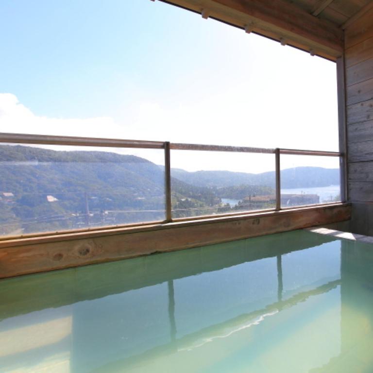 a swimming pool with a view of the mountains from a window at 箱根エレガンス in Hakone