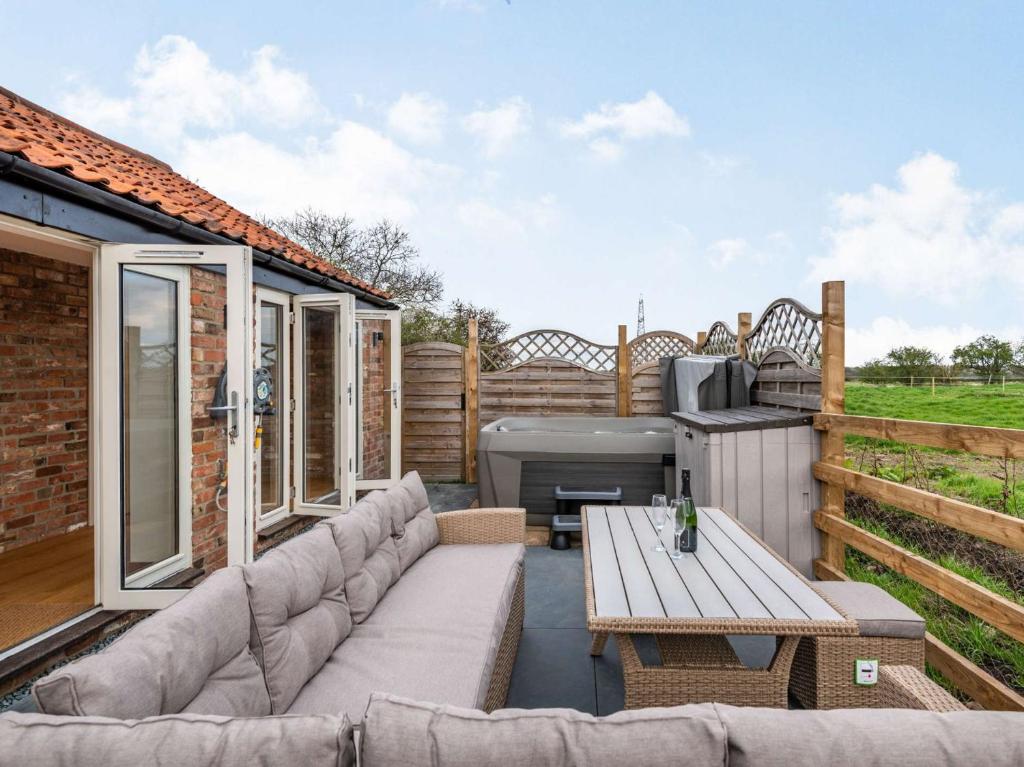 une terrasse arrière avec un canapé et un grill dans l'établissement 2 Bed in Coddington 87683, à Coddington