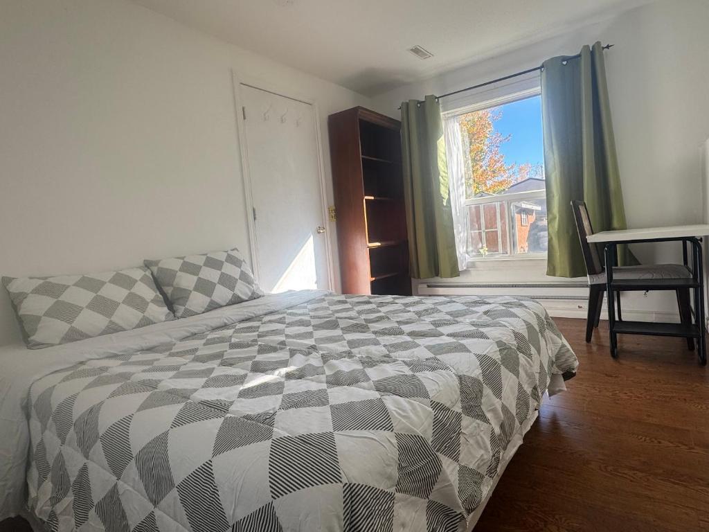 una camera da letto con un letto, una finestra e una scrivania di Cozy home a Calgary