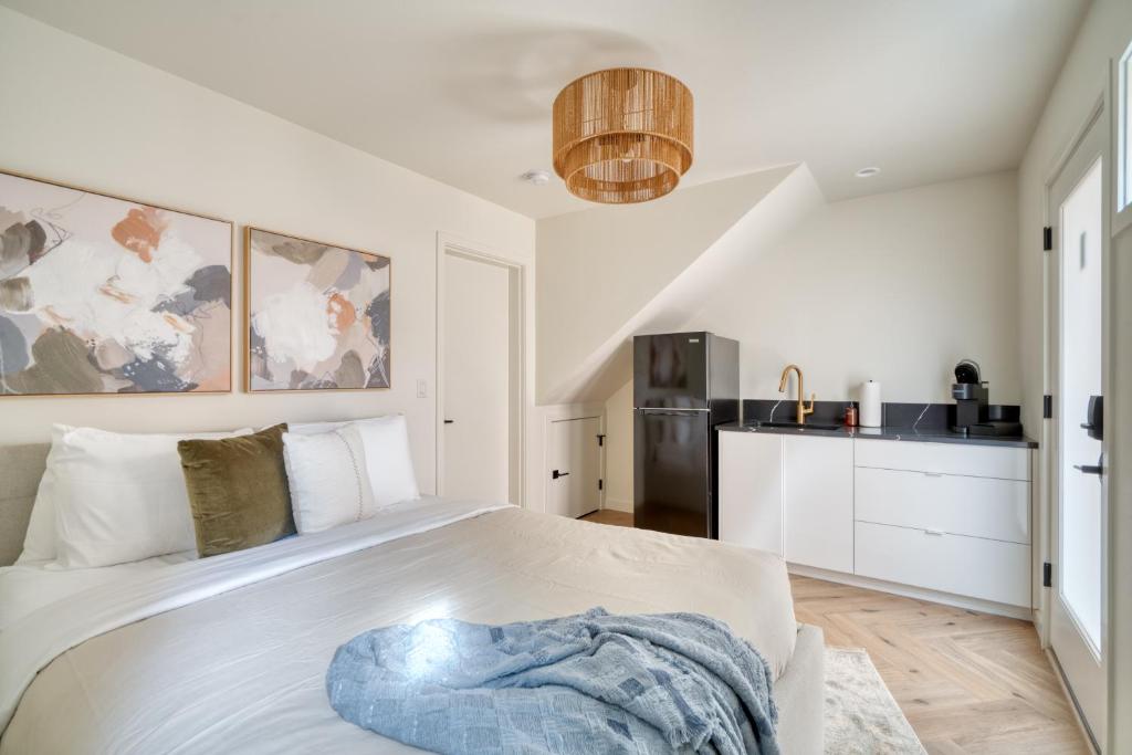 a bedroom with a white bed and a kitchen at Stay Portland - Alberta Arts District Hideaway - Stylish Studio in Portland