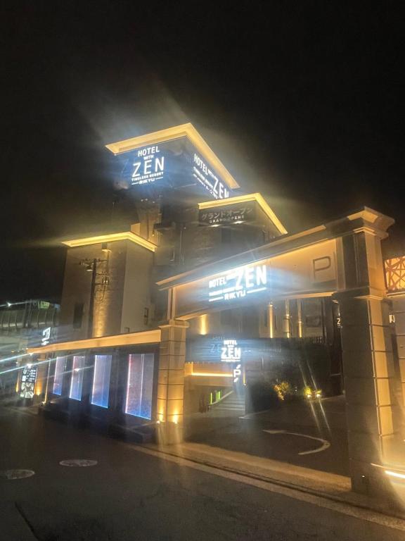 a building with a sign on it at night at Hotel ZENRIKYU横浜町田 in Yokohama