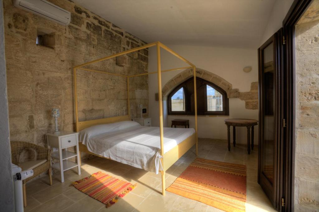 ムーロ・レッチェーゼにあるMasseria Laccoのベッドルーム(天蓋付きベッド付)が備わるアパートメントです。