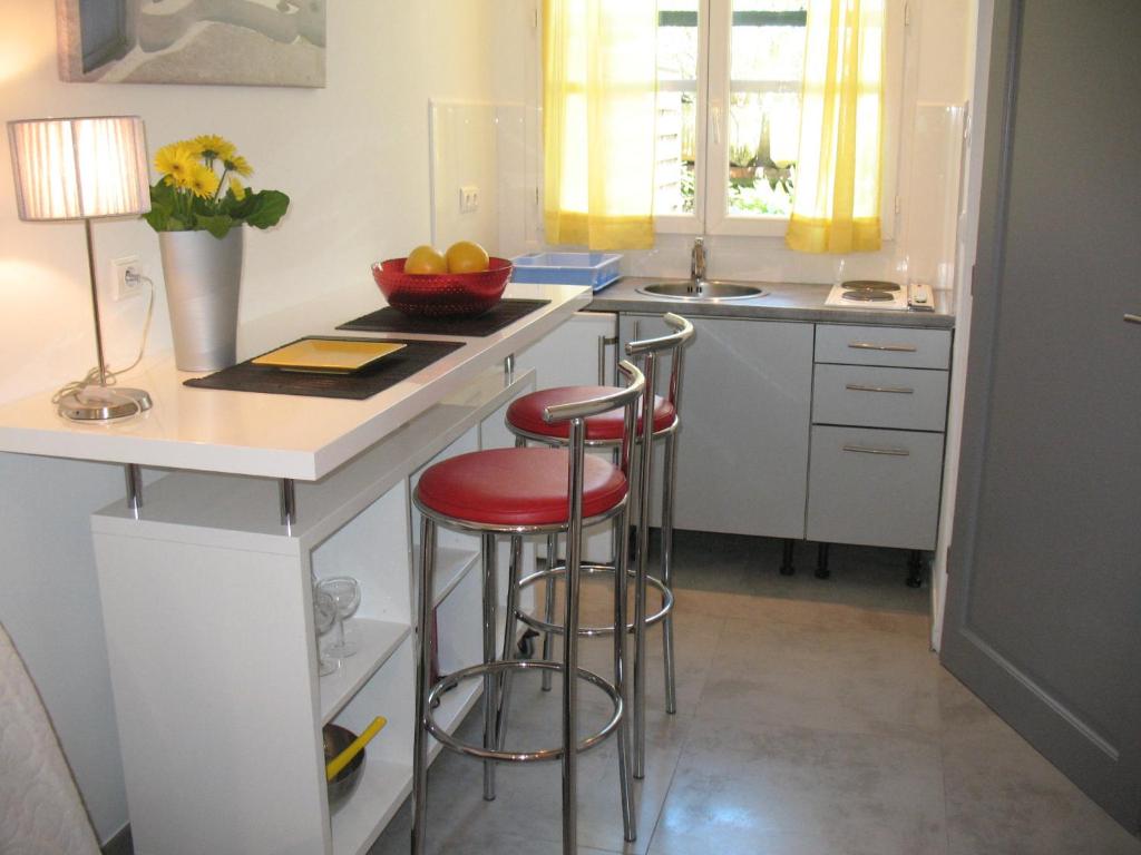 a kitchen with two bar stools at a counter at Studio du Lac in Cannes