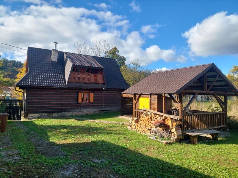 a log cabin with a gazebo in the yard at Chalúpka za Magurou in Matiašovce