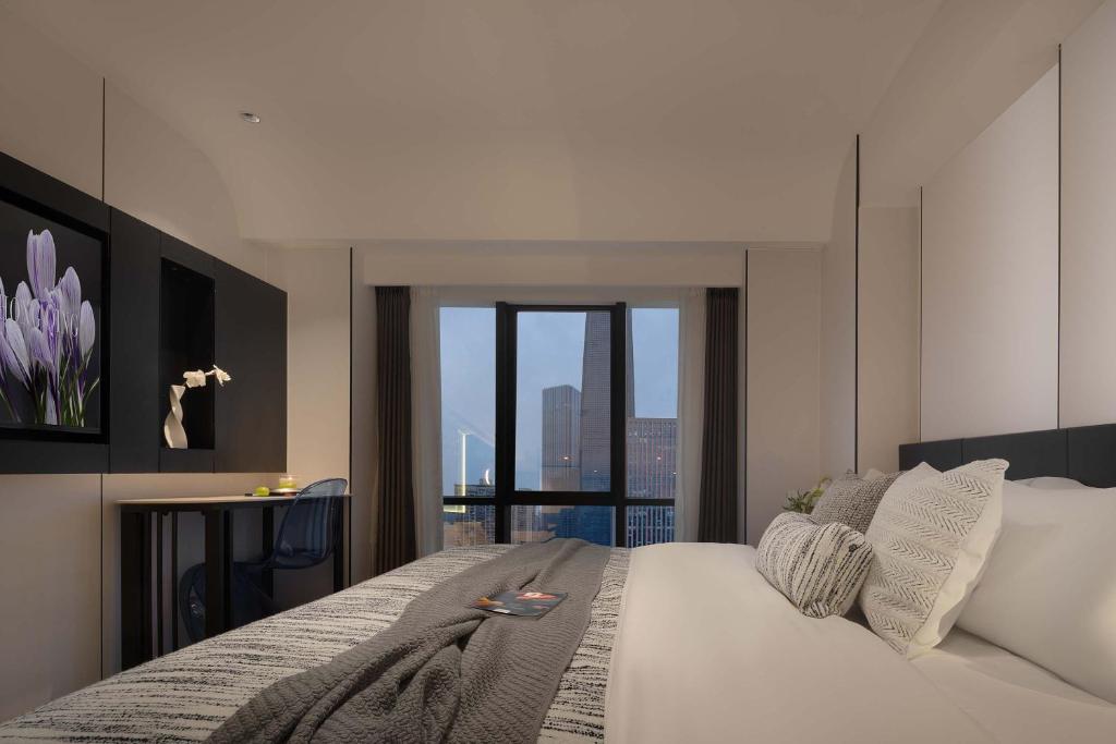 Schlafzimmer mit einem Bett und Stadtblick in der Unterkunft Chongqing Jiangbei Guanyinqiao Pedestrian Street Berry Hotel in Chongqing