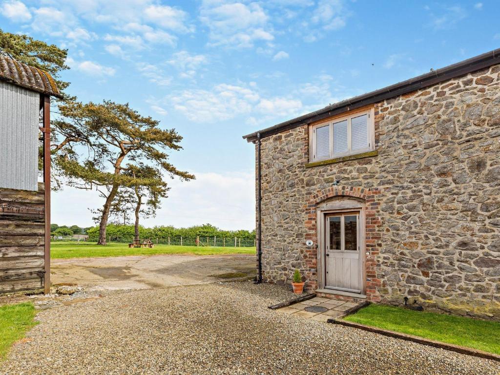a stone house with a door and a field at 1 Bed in Ludlow 94662 in Letton