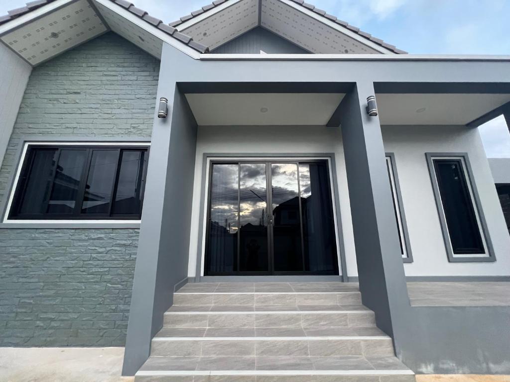 a house with a glass door and stairs at SRE- Holiday Home in Prime Village, Mae Sot 