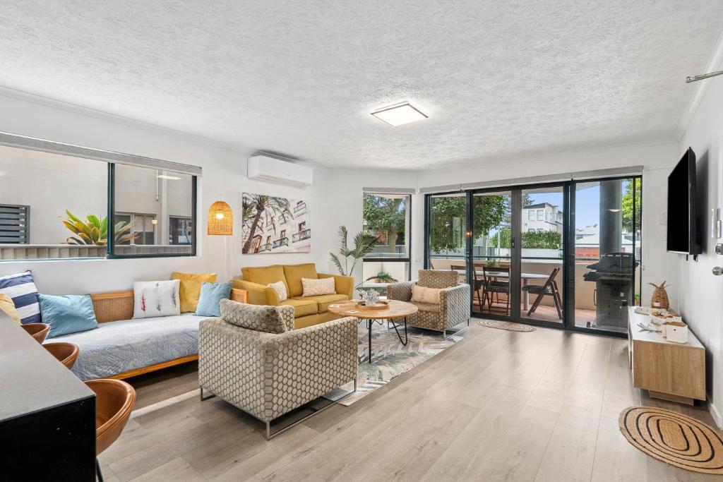 Palm Beach Paradiso في غولد كوست: غرفة معيشة مع أريكة وكراسي