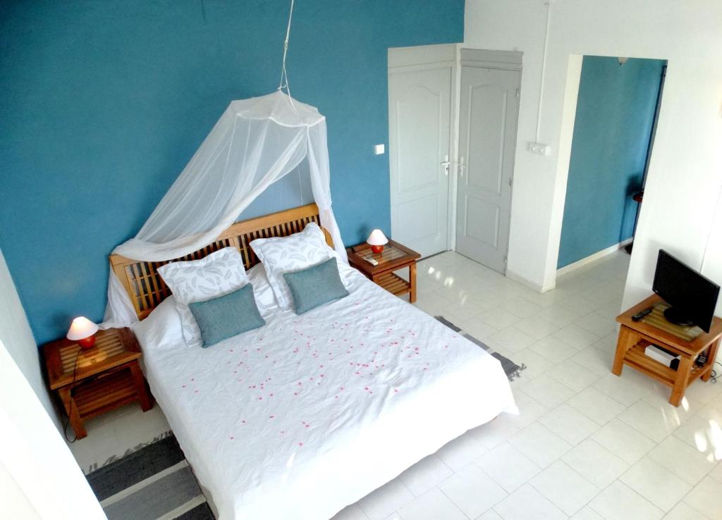 a bedroom with a white bed with a canopy at Blue Appartment in La Gaulette