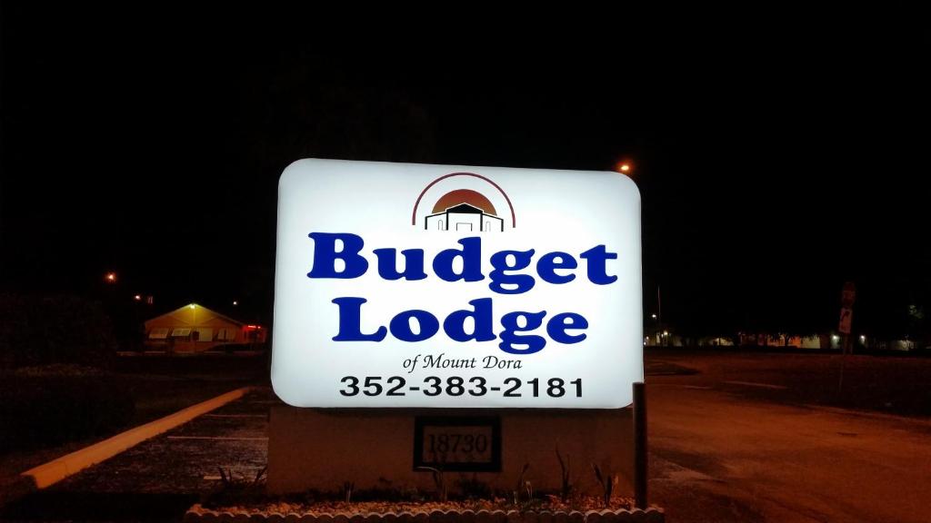 a sign for a buggie lodge at night at Budget Lodge Mount Dora in Mount Dora