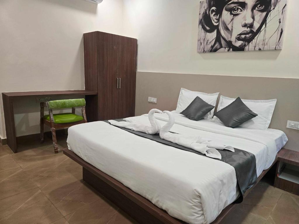 GundipetにあるHotel O EVAの壁に絵が飾られた大きなベッドのある寝室