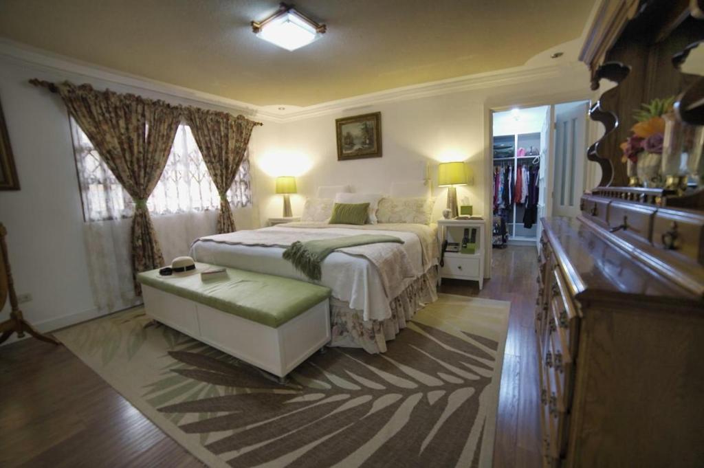 een slaapkamer met een bed, een dressoir en een wastafel bij casa de ensueño in Cuenca