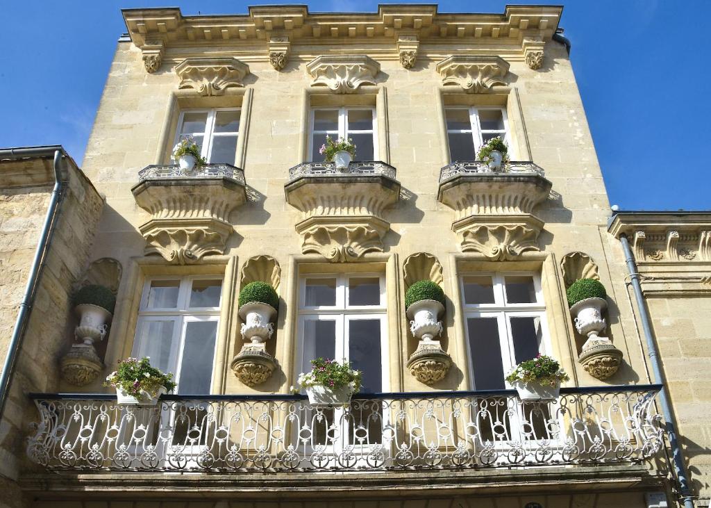 un bâtiment avec des balcons et des plantes en pot dans l'établissement The Suites, à Blaye