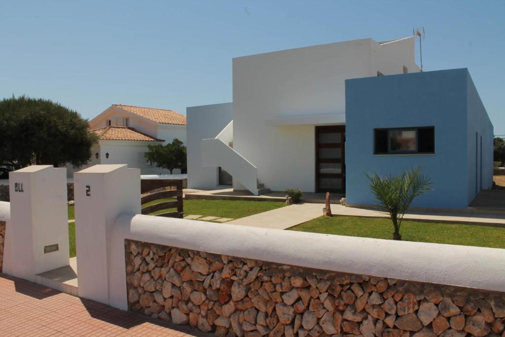 a villa with a stone wall and a house at Villa Romaní Apartament in Ciutadella