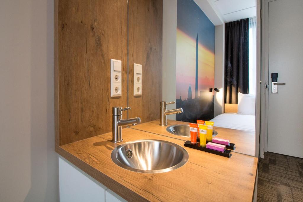 a bathroom with two sinks and a bed at Citiez Hotel Amsterdam in Amsterdam