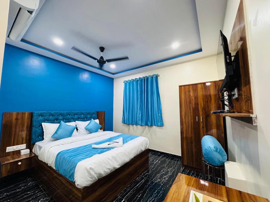 a bedroom with a bed and a blue wall at Hotel Welcome Airoli in Navi Mumbai