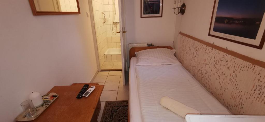 una pequeña habitación con una cama y una mesa en Hotel Balaton Fonyód, en Fonyód