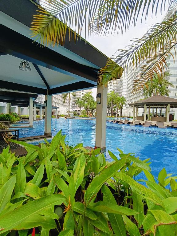une vue d'une piscine dans un complexe hôtelier dans l'établissement Shell Residences Mall of Asia by Jhem, à Manille