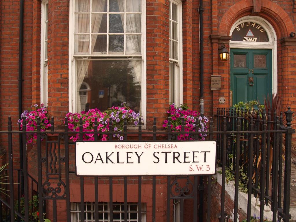 ein Schild auf einem Zaun vor einem Haus in der Unterkunft Oakley Hotel in London