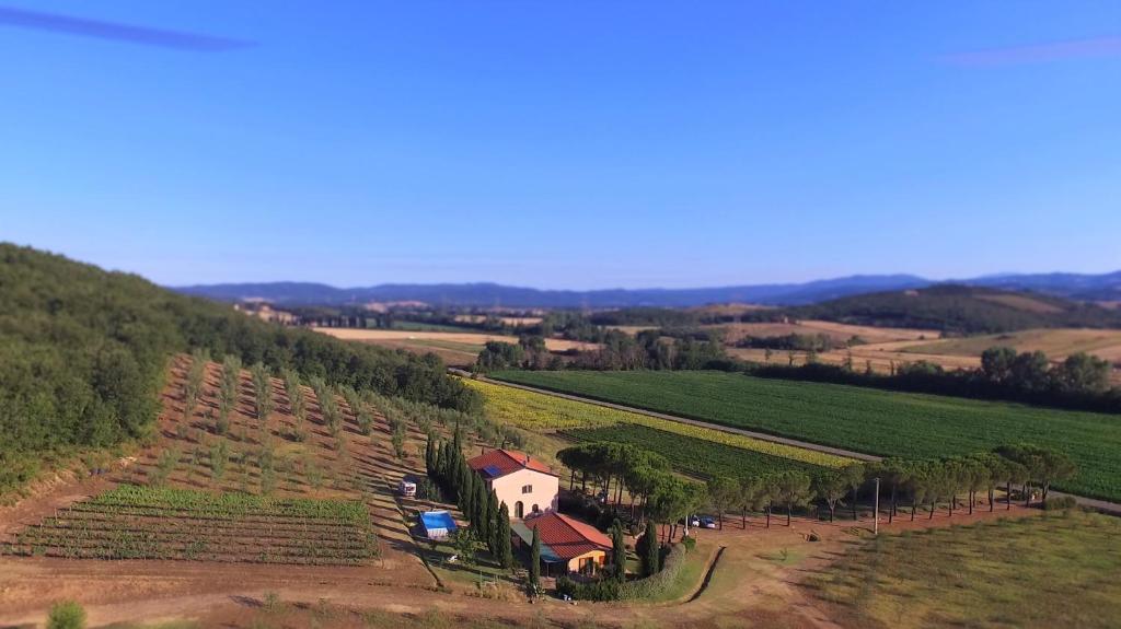 una vista aerea di una fattoria con una casa su una collina di Agriturismo Podere Mulinaccio a Ribolla