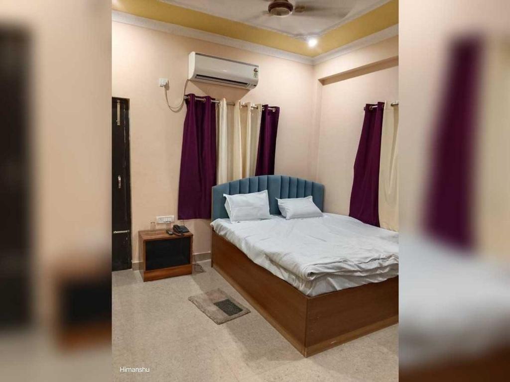 um quarto com uma cama e uma janela com cortinas roxas em Hotel O kumar inn em Lok Nayak Jayaprakash Airport