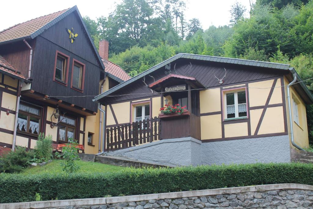 ein Haus mit einer Veranda und einem Zaun in der Unterkunft Haus Hubertus in Stolberg i. Harz