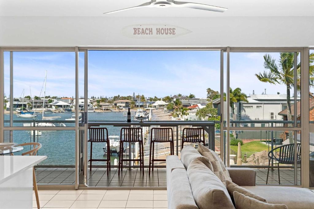 a living room with a couch and chairs on a balcony at Serenity Waters Riverfront Retreat - Walk to Mooloolaba in Mooloolaba