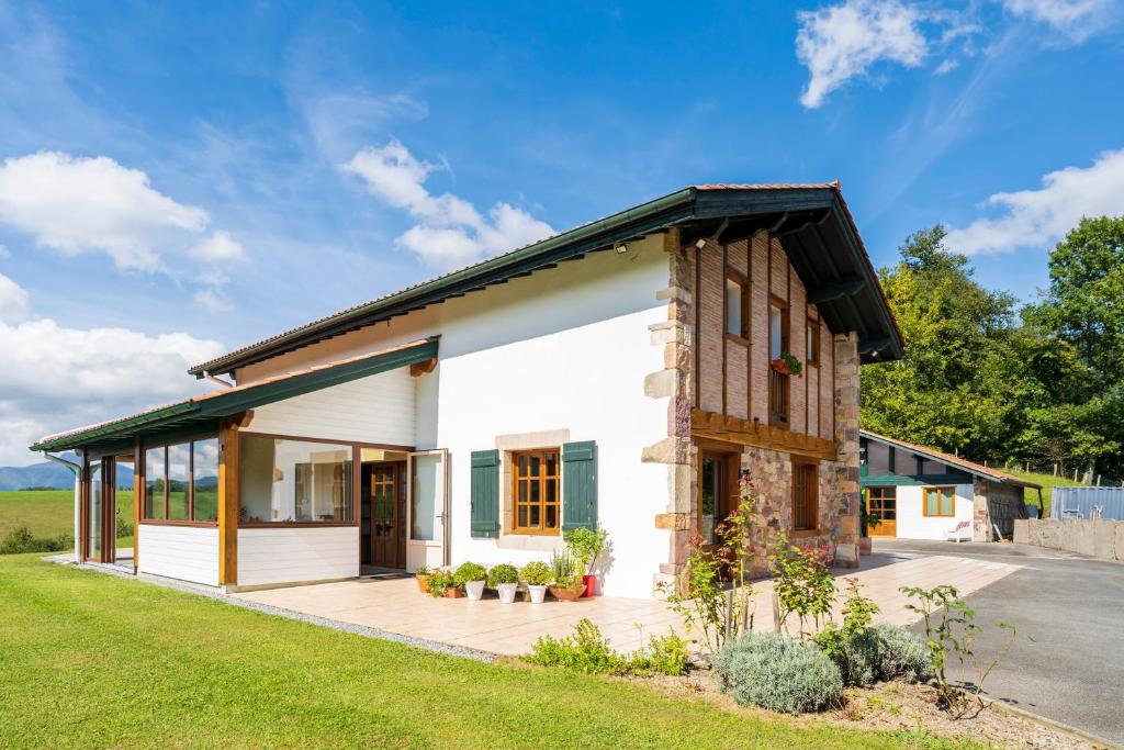 een wit huis met een gambrel dak bij goitik ikusita in Aïnhoa