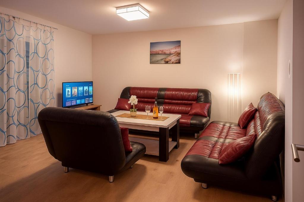 a living room with a leather couch and a table at Apartman Sofija in Teslić