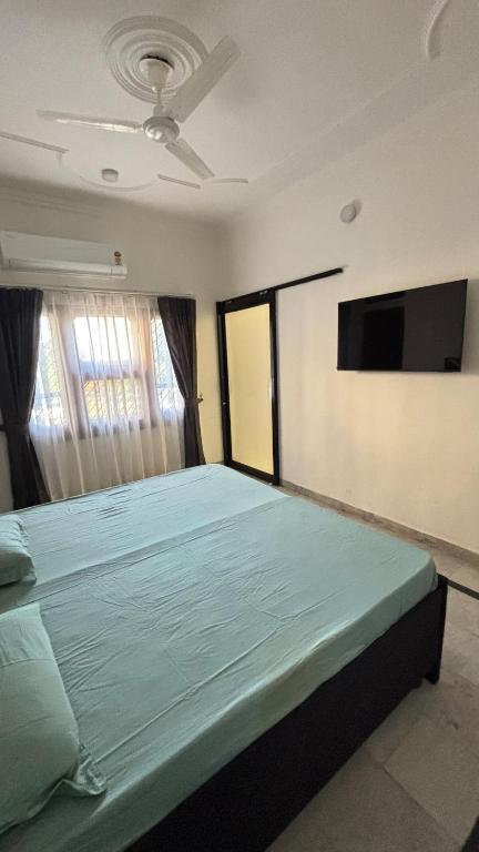 a bedroom with a large bed and a flat screen tv at ProxyHome in Kālka