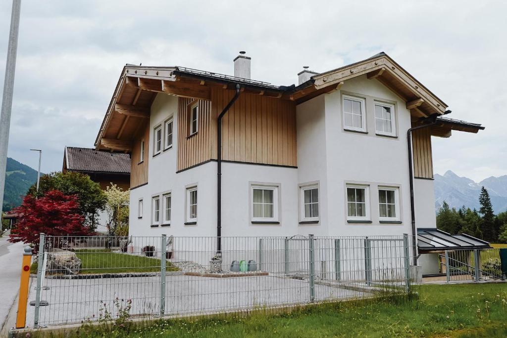 uma casa branca com um telhado de madeira em Das Haus am Waldsee em Maishofen