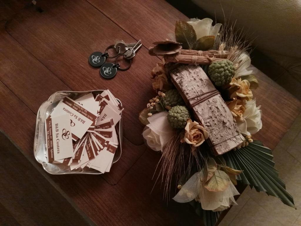 un tavolo con un mazzo di fiori e un mazzo di cibo di B&B Sa Costera a Iglesias