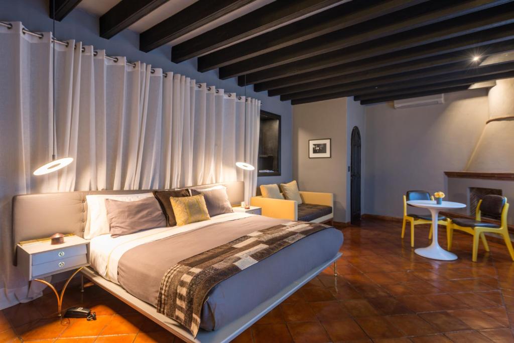 a bedroom with a bed and a table and chairs at Dos Casas Hotel & Spa in San Miguel de Allende
