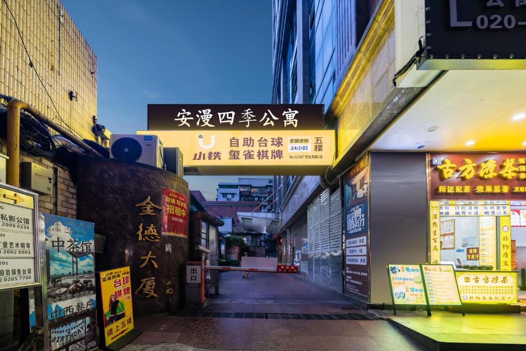 eine Gasse in einer asiatischen Stadt mit Schildern in der Unterkunft Anman Four Seasons Apartment (Beijing Road Pedestrian Street Branch) in Guangzhou