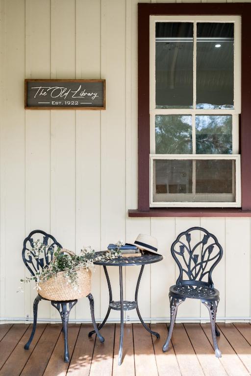 two chairs and a table on a porch at The Old Library in Balnarring Beach