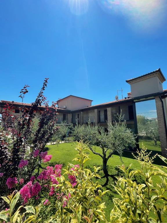a garden with flowers in front of a building at Hotel Relais Agli Olivi in Lazise