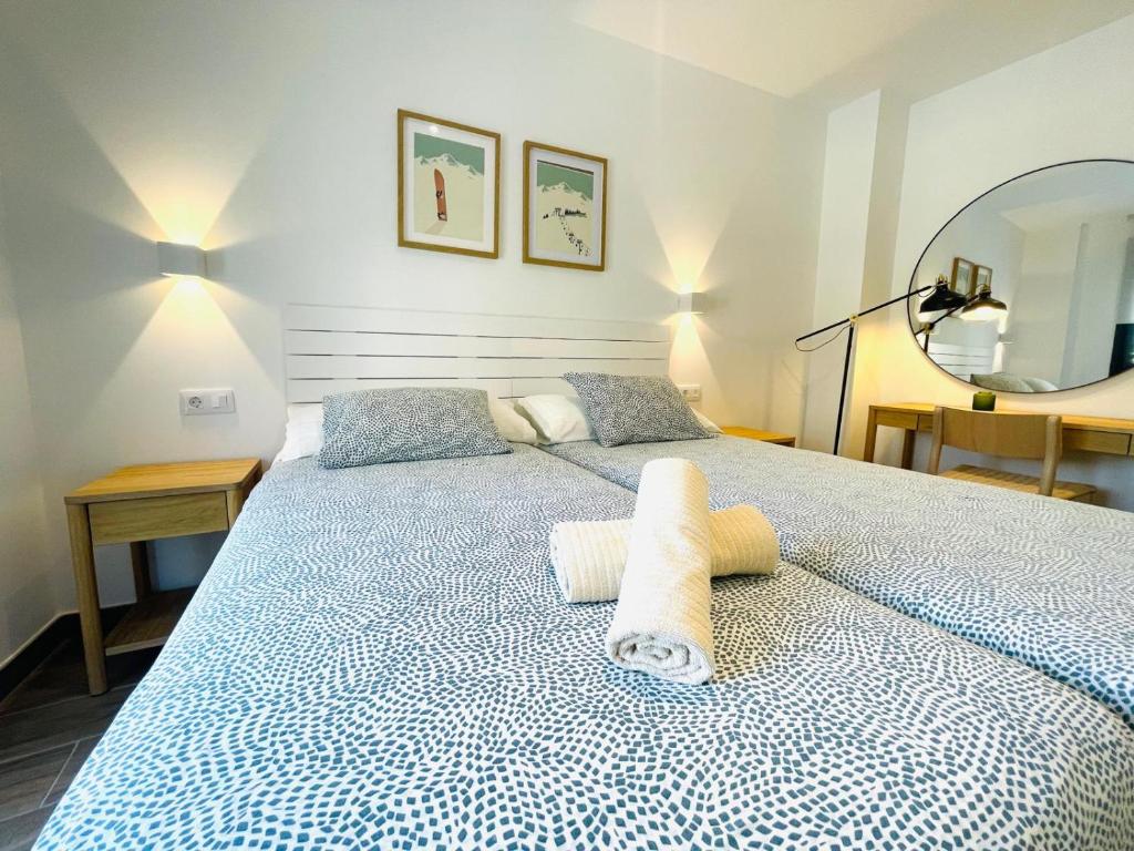 a bedroom with a bed with two towels on it at Apartamentos San Nicolas Jaca in Jaca