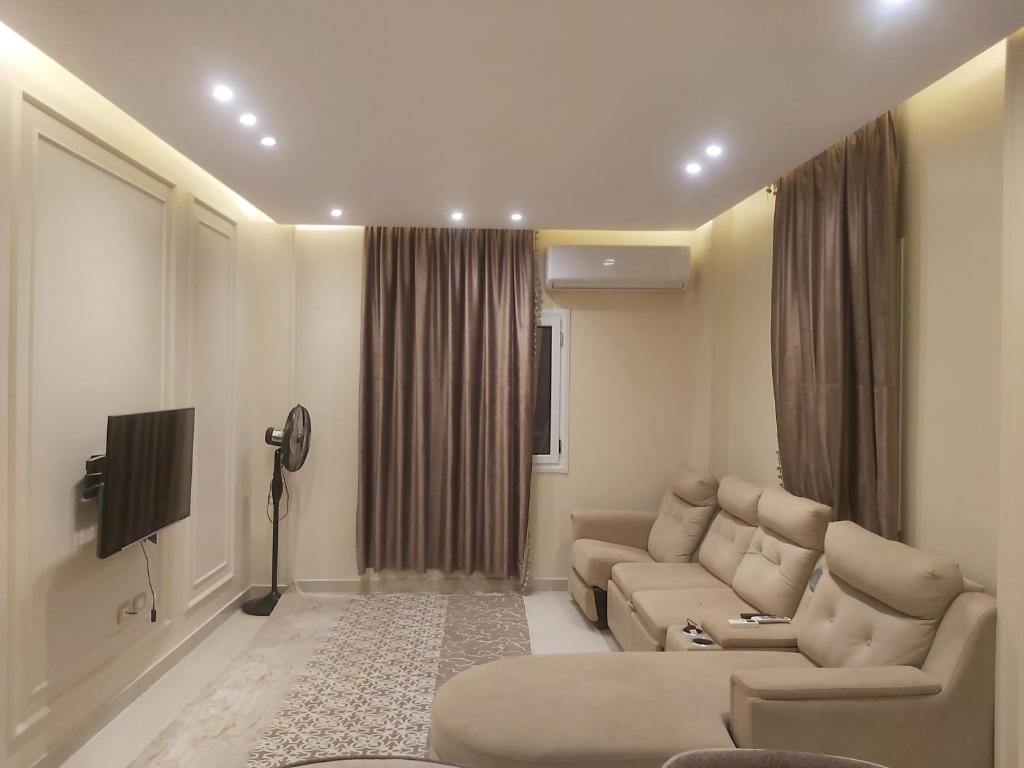 a living room with a couch and a tv at White Rose in New cairo