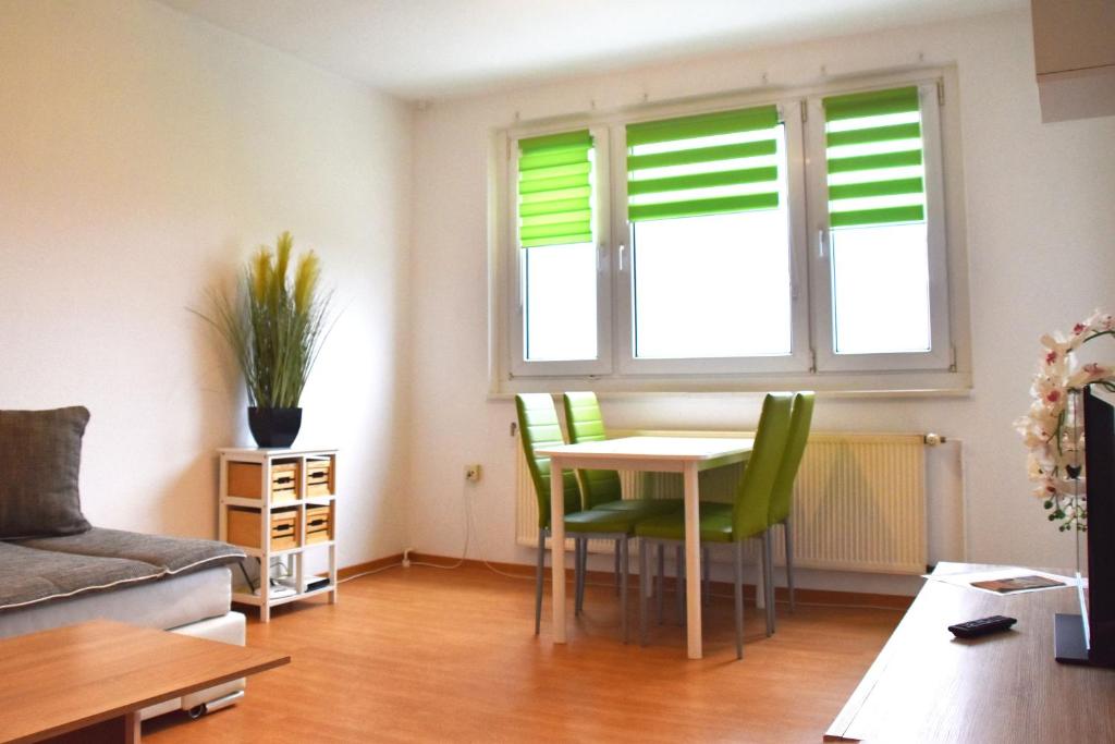 - un salon avec une table et des chaises vertes dans l'établissement GUWO Gästewohnung Platanenstraße 1, à Sprucke